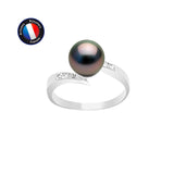 La Bague ONDINE de Perlinea est une bague en argent avec une perle de Tahiti foncée au centre et des pierres claires sur la bande. Un écusson circulaire bleu et rouge en haut à gauche indique Artisanat Bijouterie Française.