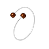 Le Bracelet Jonc KATALÏA | Perles Chocolat de Perlinea est un bracelet ouvert minimaliste en argent 925, orné de deux perles sphériques brunes, présentées sur fond blanc.