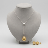 Collier pendentif perle dorée sur chaîne argentée et boucles d'oreilles perle dorée.