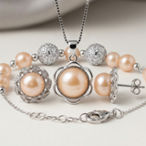 Parure collier, boucles d'oreilles et bracelet perles roses sur fond neutre.