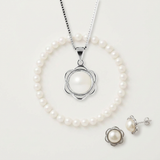 Parure blanche : collier pendentif, bracelet et boucles d'oreilles en perles sur fond neutre.