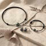 Parure collier, bracelet et boucles d'oreilles à perles de Tahiti sur cordon noir.